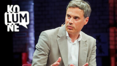 Norbert Himmler sitzt vor einem dunkel-lila Hintergrund