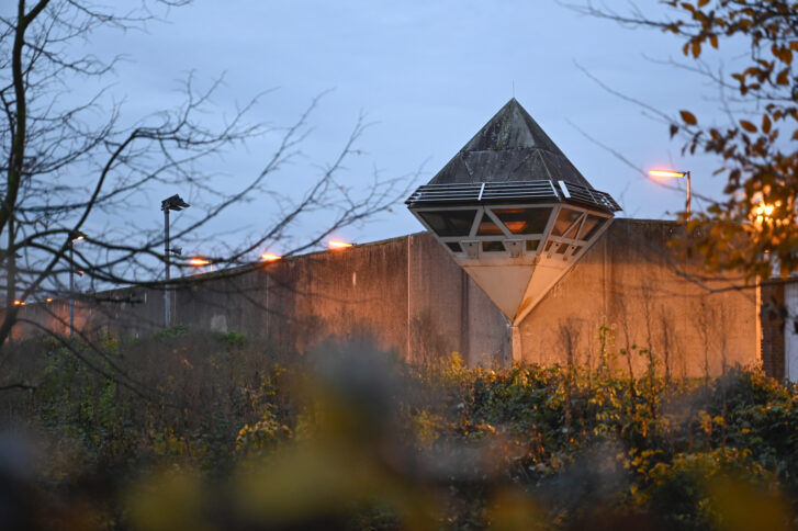 Eine Mauer im Morgengrauen, darauf ein Wachturm.