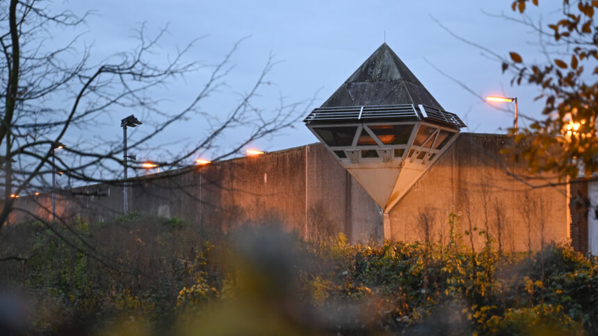 Eine Mauer im Morgengrauen, darauf ein Wachturm.