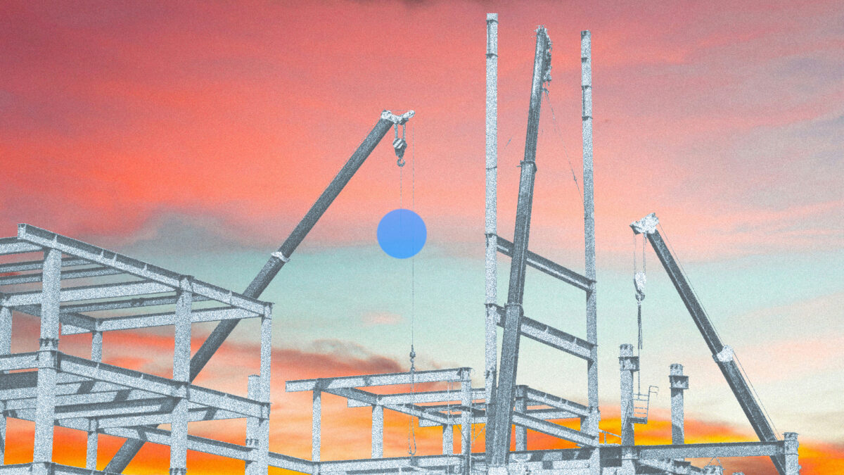 Eine Baustelle im Morgenrot, an einem Kran hängt ein blauer Punkt