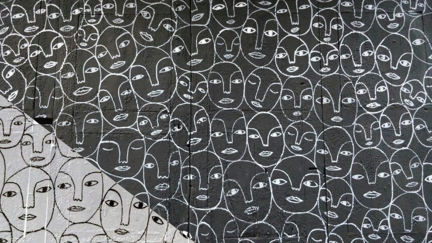 Strichzeichnungen von Gesichtern auf einer Wand.