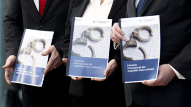 Menschen halten die Kriminalstatistik für ein Foto in der Hand.