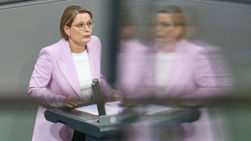 Person im lila Blazer steht an Rednerpult im Bundestag
