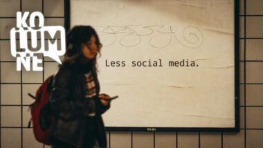 Eine Person vor einer Plakatwand mit dem Schriftzug: "Less social media", zu Deutsch: "Weniger soziale Medien"