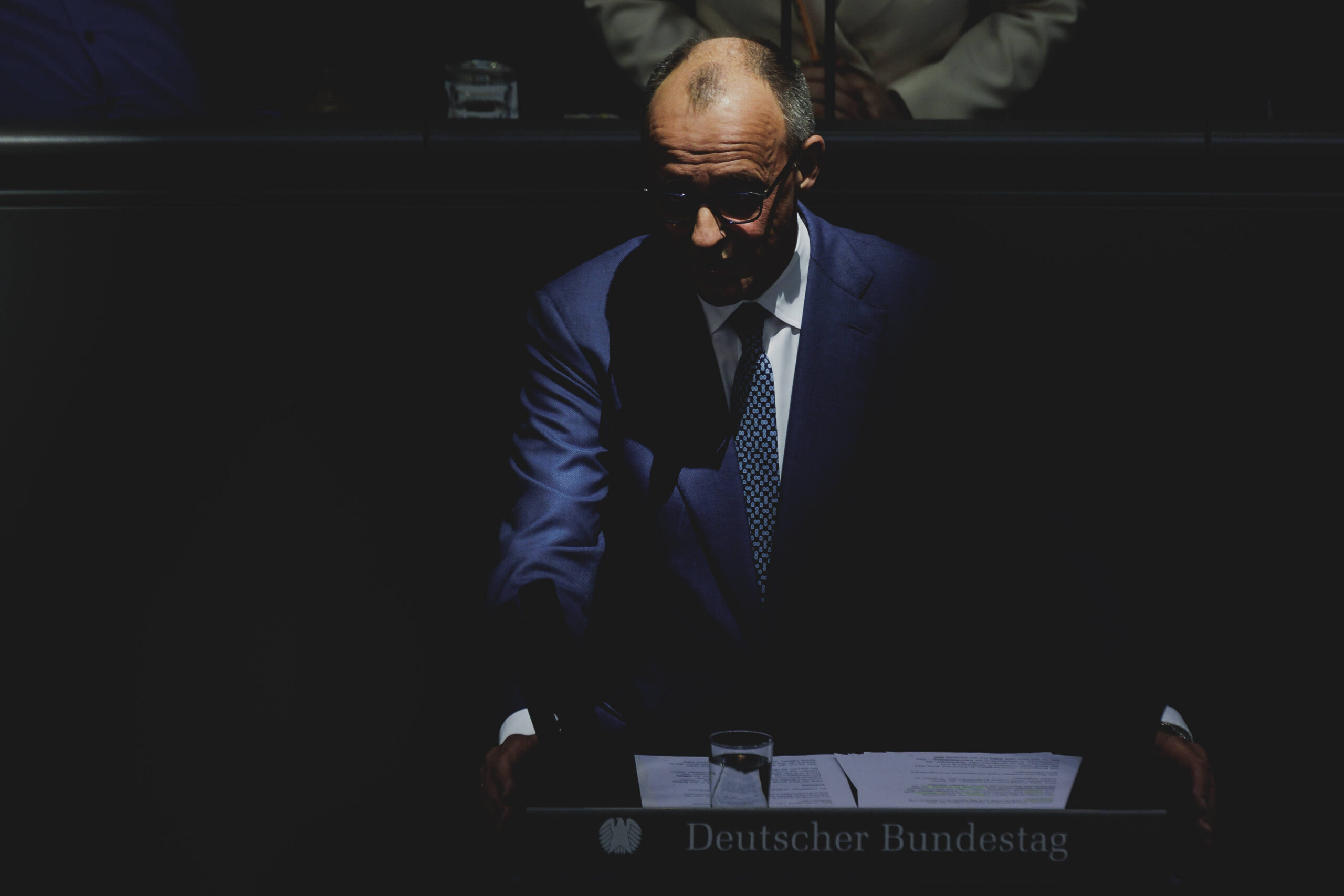 Friedrich Merz CDU, Bundeskanzler, aufgenommen waehrend seiner Regierungserklaerung zum Europaeischen Rat im Deutschen Bundestag in Berlin, 18.03.2026, durch Lichteinfall oder Bearbeitung sieht es so aus, als würde der Bundeskanzler im Dunkeln am Redepult stehen und selbst nur leicht beleuchtet sein