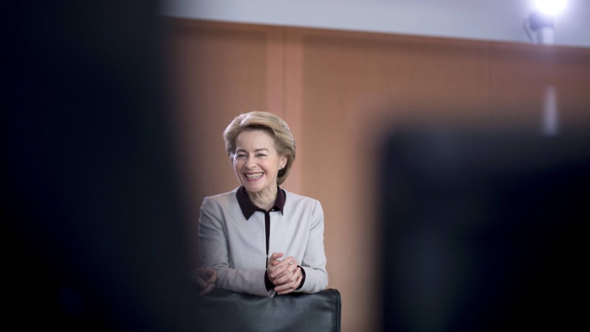 Eine lachende Ursula von der Leyen, im Vordergrund ominöse Schatten.