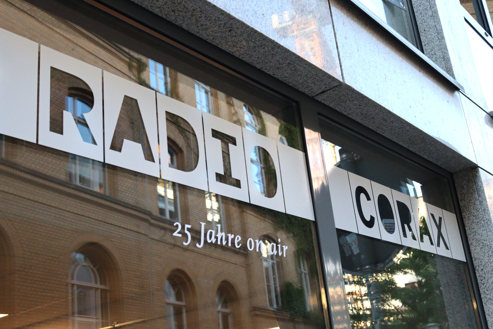 Auf einer großen Fensterscheibe steht in Großbuchstaben "Radio Corax" geschrieben.