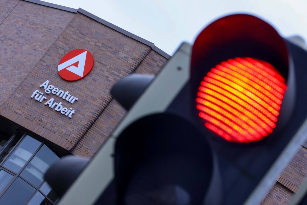 Eine Ampel leuchtet rot,, dahinter ist das braune Gebäude des Bundesagentur für Arbeit in Nürnberg.