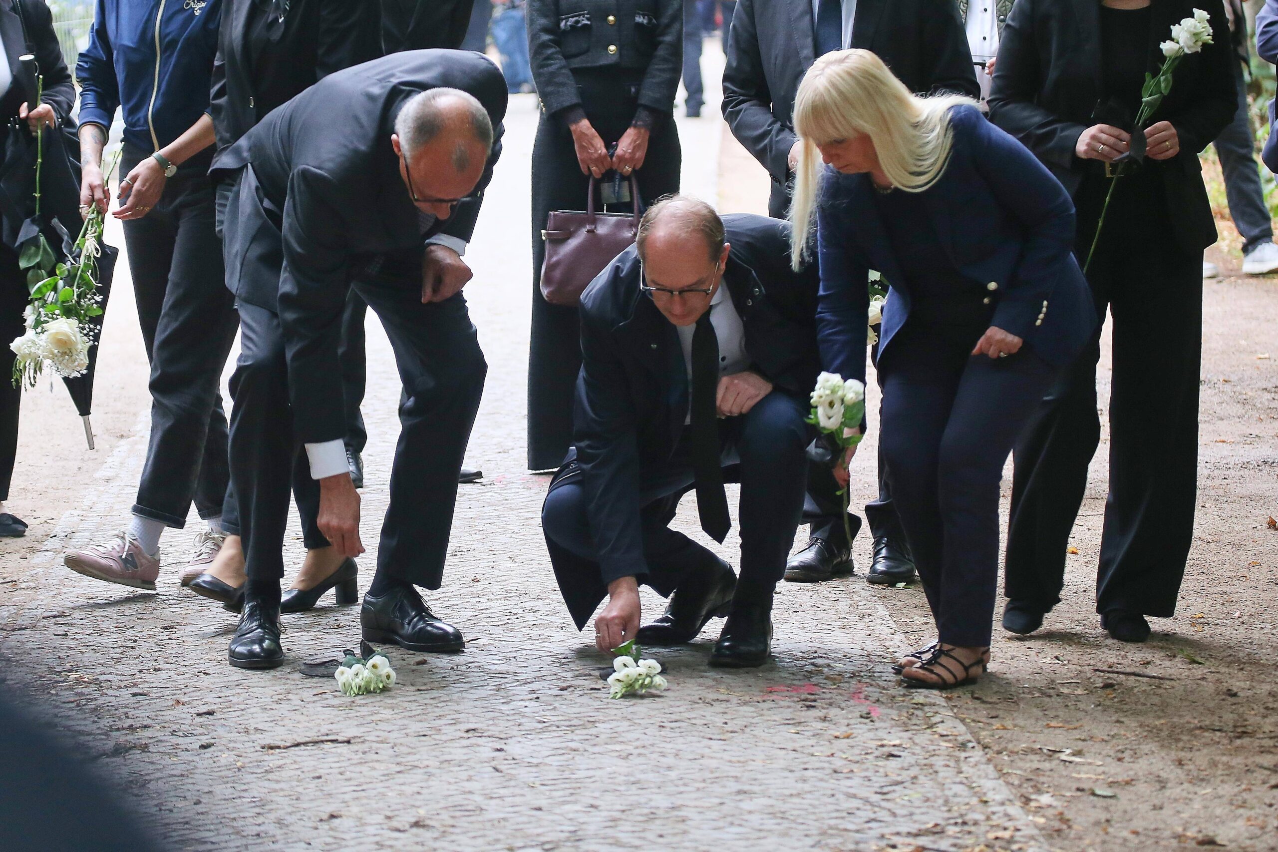Kanzler Merz, Innenminister Dobrindt und Berliner Senatorin für Inneres Spranger legen Blumen in der Nähe des Anschlagsorts nieder.