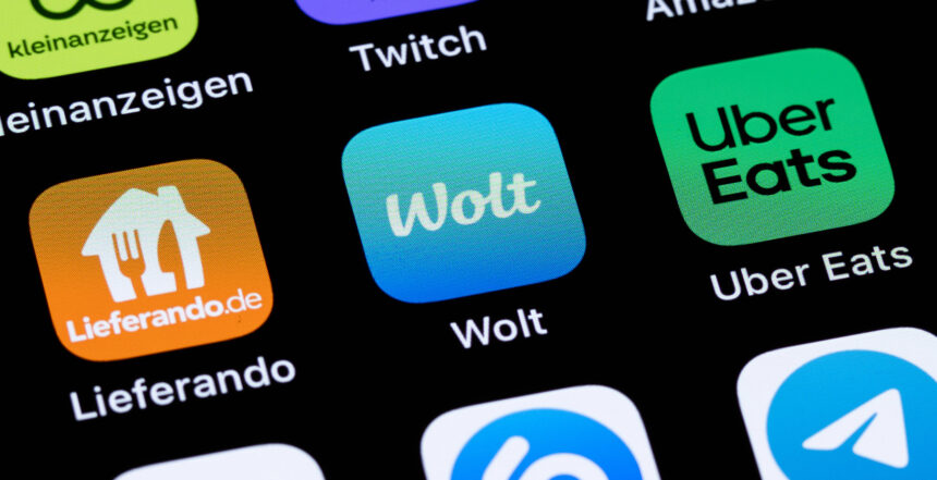 Logos der Plattformen Lieferando, Wolt und Uber Eats auf einem Handy-Bildschirm