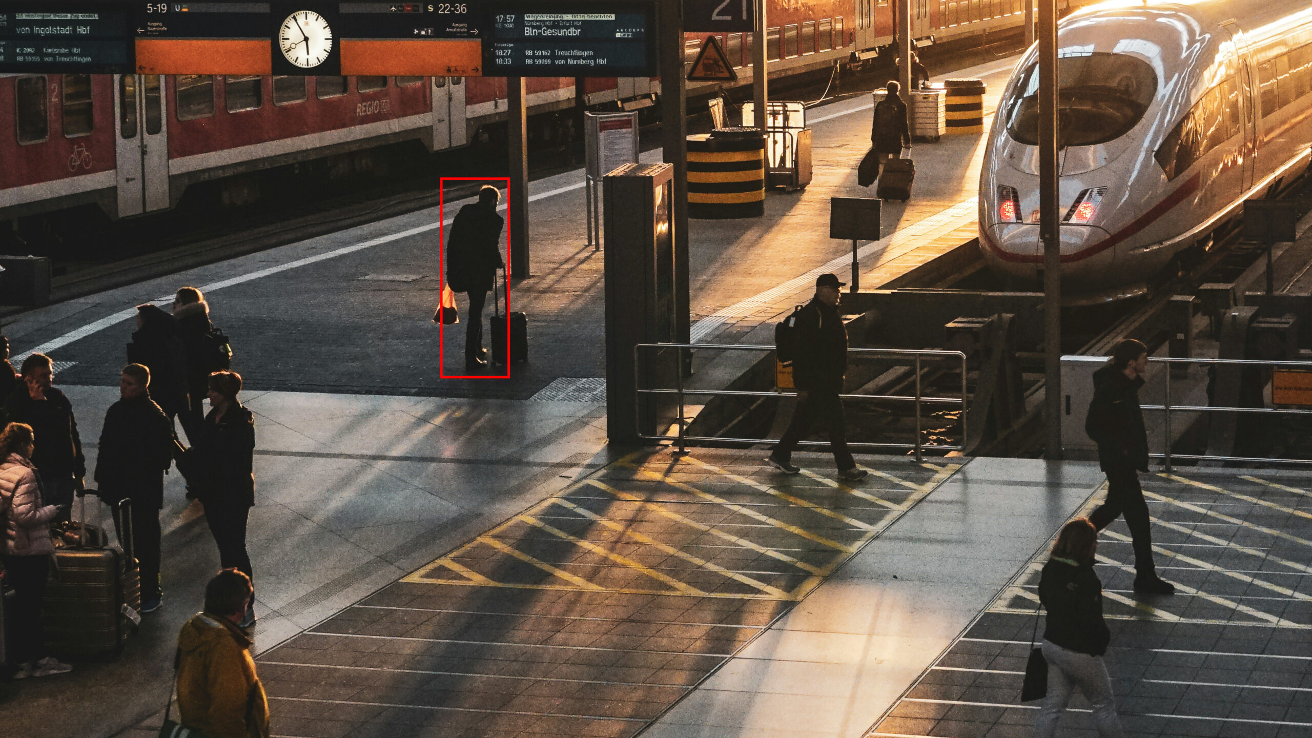Ein belebter Bahnhof, eine Person ist mit einem roten Rechteck markiert.