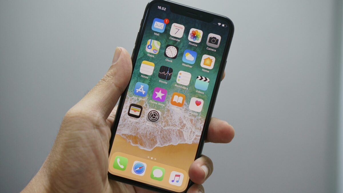 eine Hand hält ein entsperrte iPhone