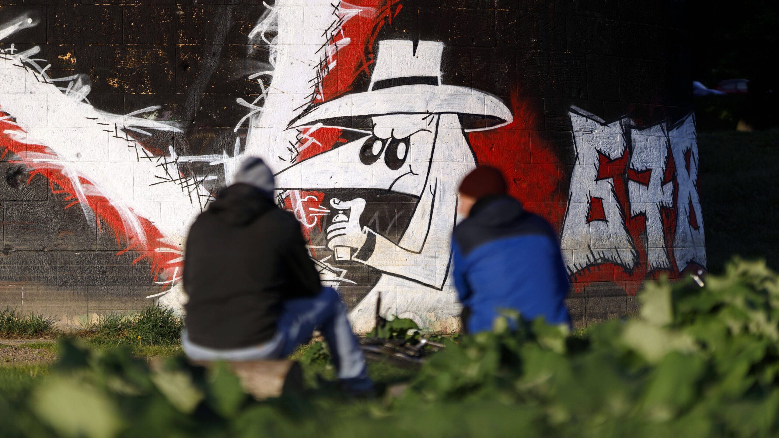 Ein Graffiti mit einem Spion, der einen weißen Hut aufhat