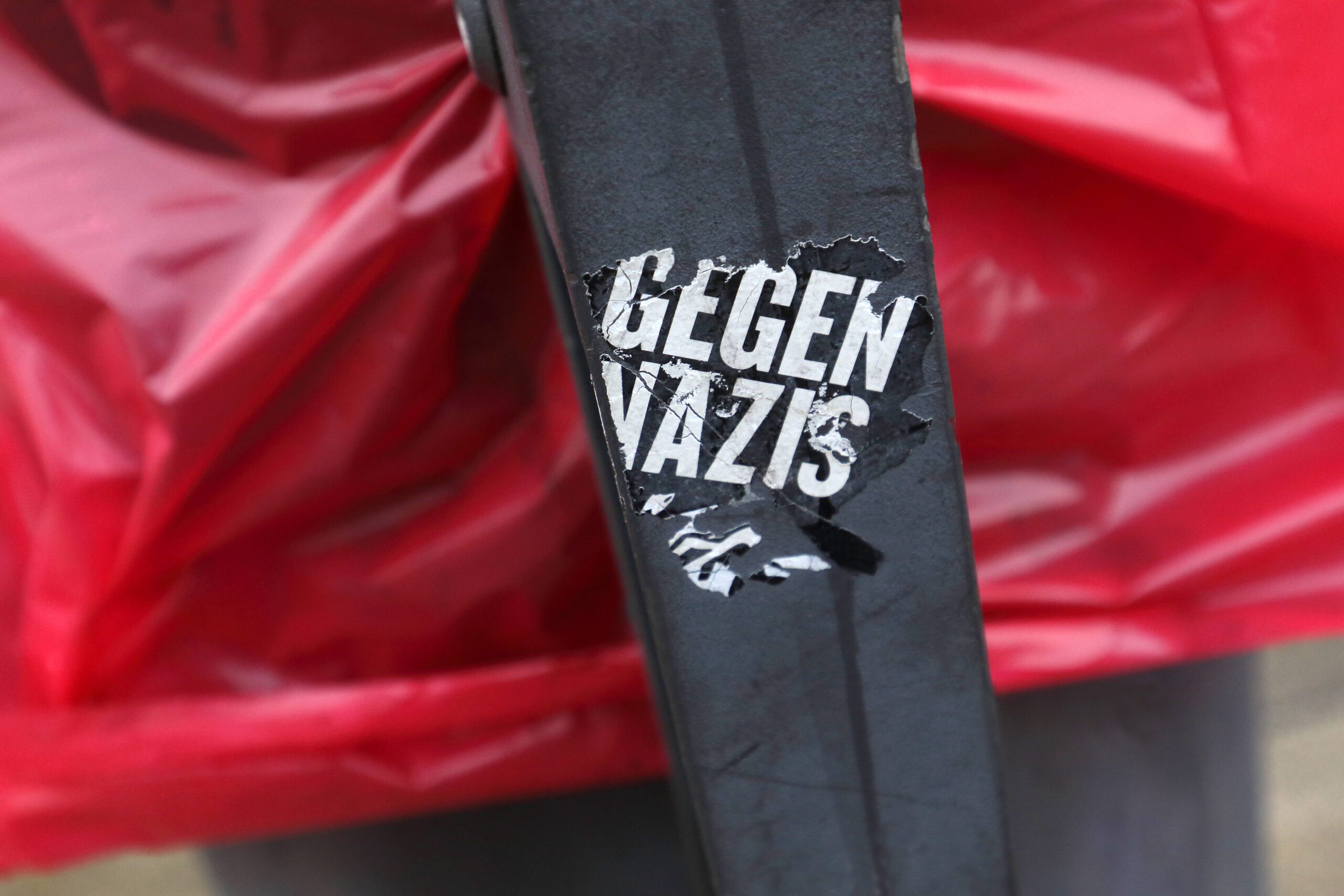 Ein Sticker auf einem Mülleimer. Darauf steht: Gegen Nazis