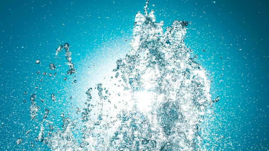 Eine Wasserfontäne vor hellblauem Hintergrund