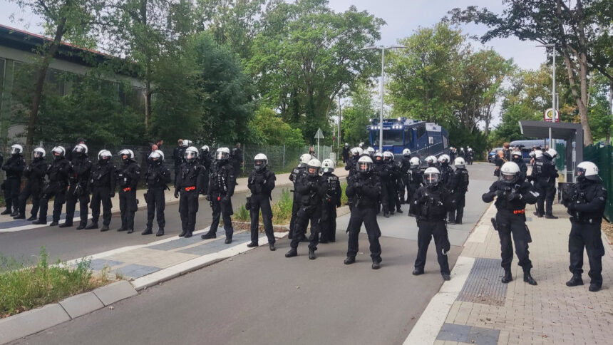 Eine Reihe von Polizist*innen sperrt eine Straße.