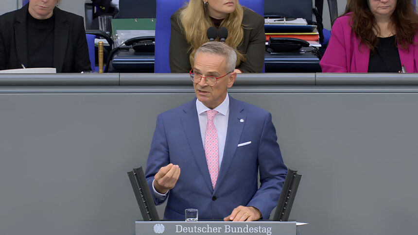 Ein Redner im Bundestag mit rosa Krawatte und blauem Sakko.