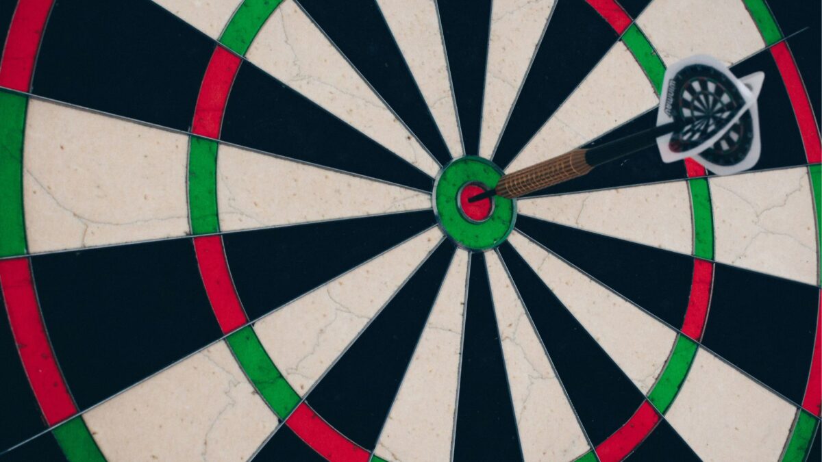 Ein Pfeil steckt im Ziel einer Dartscheibe