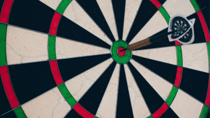Ein Pfeil steckt im Ziel einer Dartscheibe