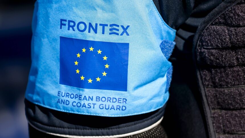Mensch mit hellblauer Frontex-Weste von hinten fotografiert