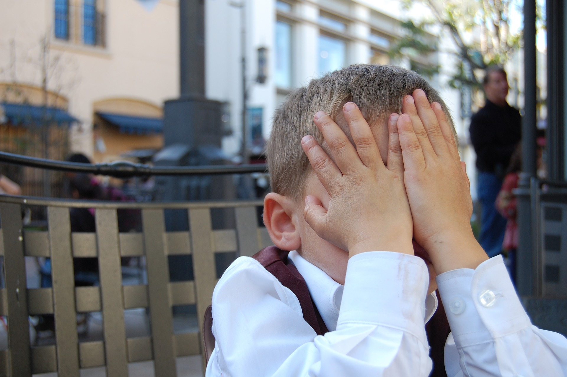 Kind mit Händen vor dem Gesicht